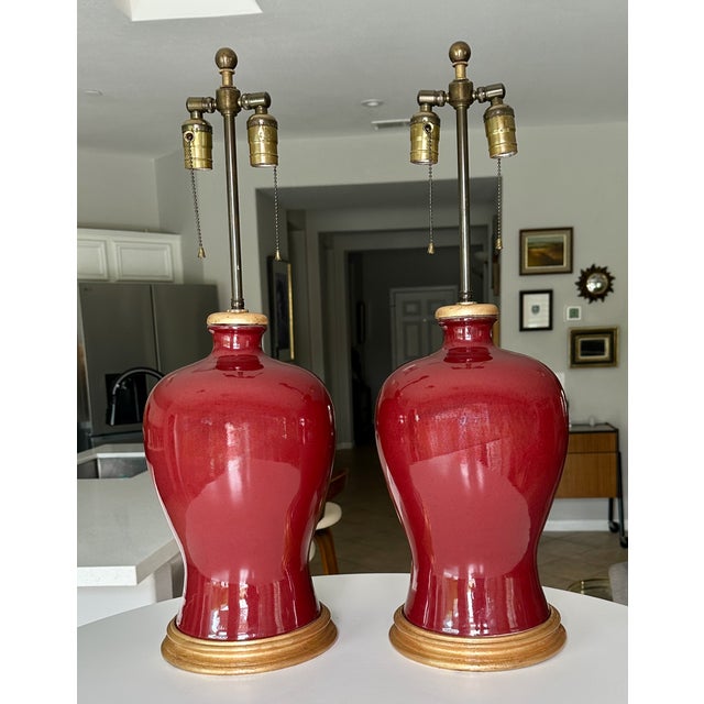 Pair of vintage Asian Sang De Boeuf "Oxblood" glazed vases as table lamps mounted on giltwood bases. They have the Meiping...