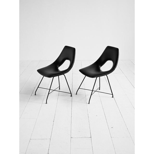 Black vinyl chairs with metal frames and brass tips. Designed by Augusto Bozzi, manufactured by Saporiti, 1950s-1960s....