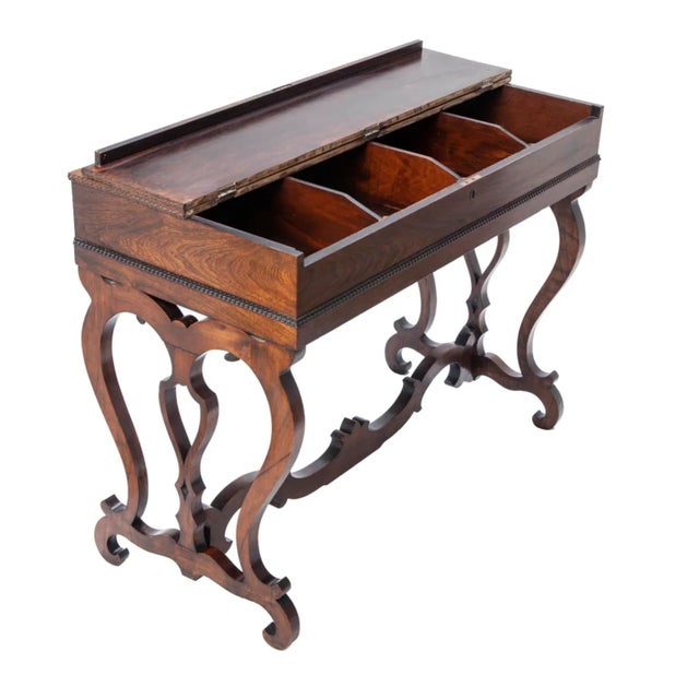 Early 19th century handcrafted rosewood writing table/desk featuring a flip-top that opens to reveal fitted storage...