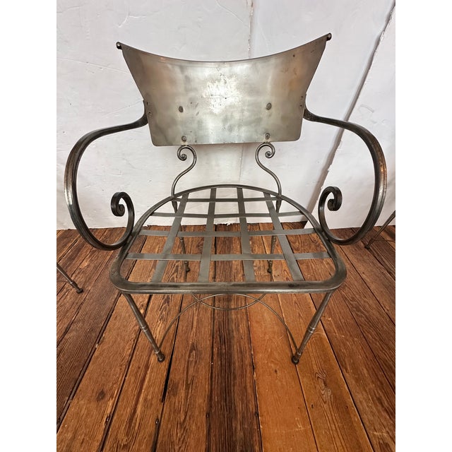 Set of 5 vintage hand forged steel armchairs crafted in neoclassical Hollywood Regency style. The curved metal backrests,...