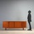 1960s sideboard featuring a functional design typical of the era. Made from teak veneer wood, it offers a refined...