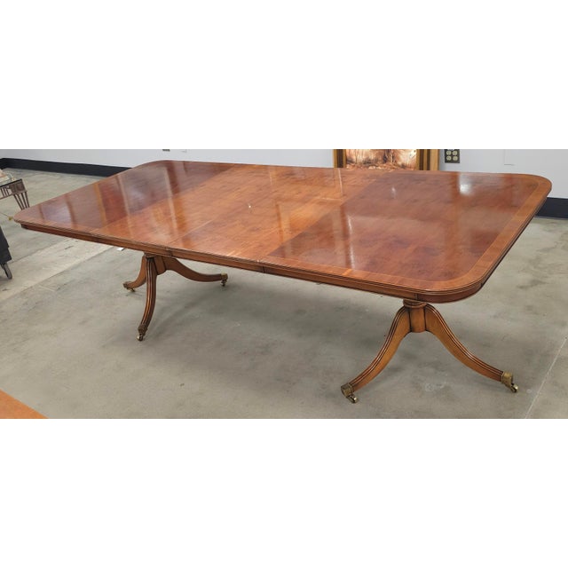 A Yorkshire Georgian Style Yew Wood Banded Extension Dining Table Table is 62.5" wide without leaf, comes with two bagged...