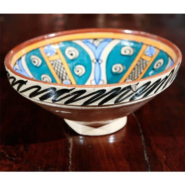 An under-glazed painted pottery bowl with abstract naive design, blue, ochre, brown. Moroccan antique pottery bowl of deep...