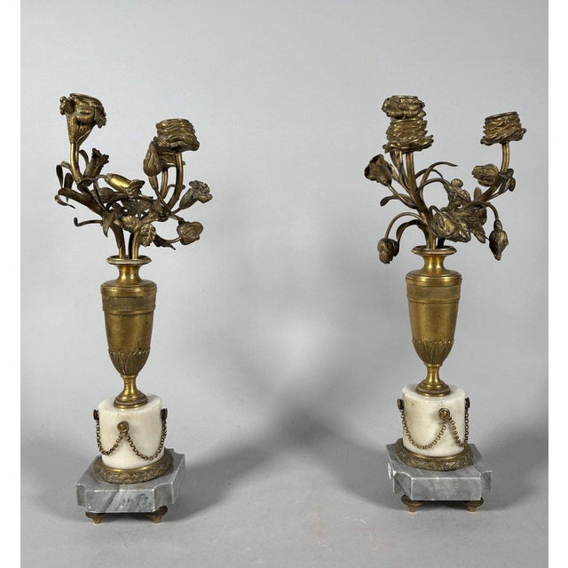 Pair of candelabra with vases of flowers. Chiseled bronze resting on white and blue Turquin marble bases. French work from...