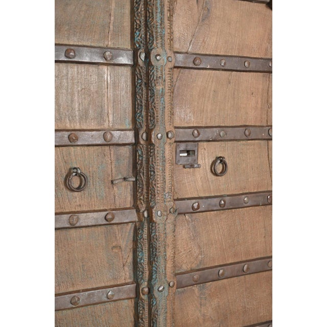 Antique Indian Carved Teakwood and Iron Door, the top with a shaped arch, with a carved outline and center style. A very...