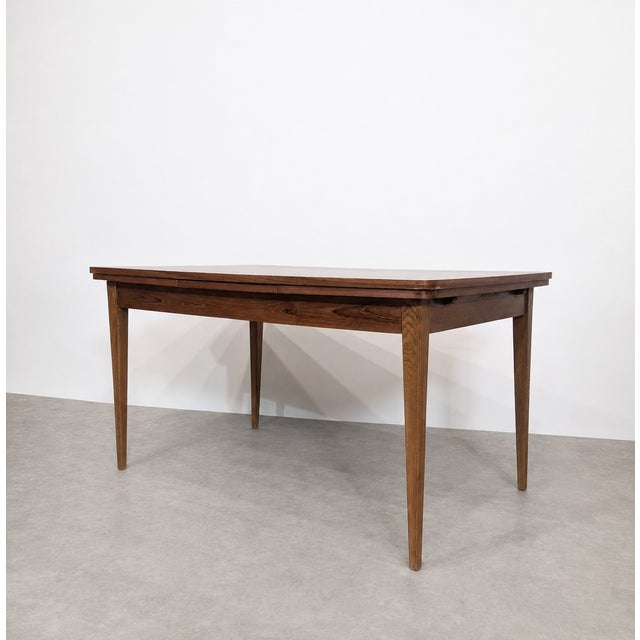 Rectangular Scandinavian-style dining table from around 1960. The satin teak veneer tabletop features a contrasting grain,...