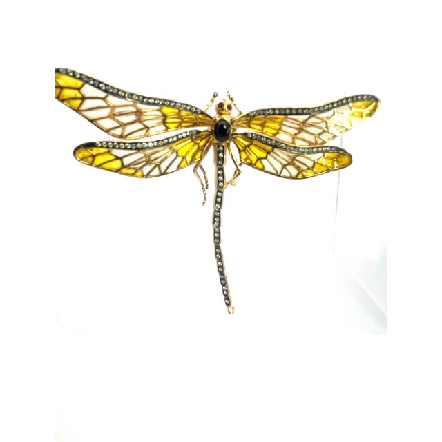 This dragonfly brooch is a striking example of plique-à-jour craftsmanship. Its four outstretched wings are built from...
