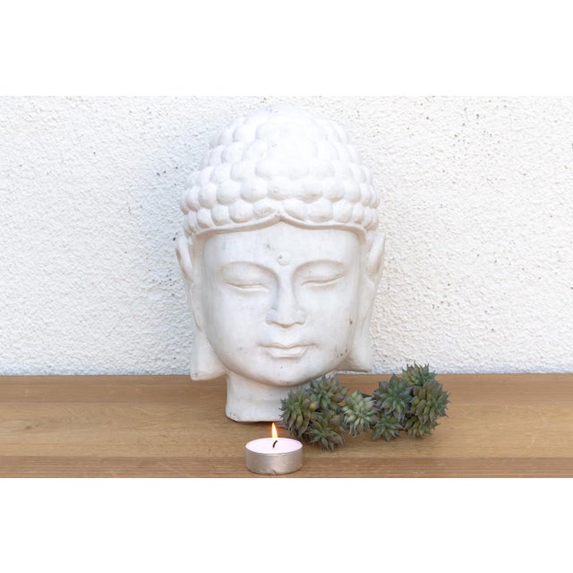 Carved from a single, heavy block of solid white marble. This piece captures the classic iconography of the Buddha in a...