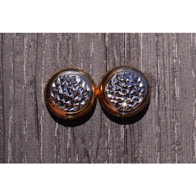 The Button: Two Tone Diamond Cut Button Earrings. The earrings feature a rhodiumed center with expert diamond cutting...