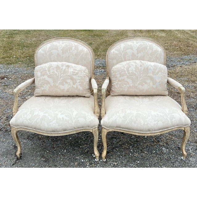 Pair of classically styled Louis XV Bergere Chairs. Carved cabriolet legs, with very nice trellis back. The chairs have an...