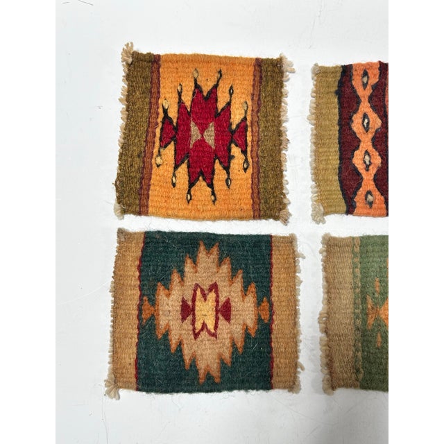 A vibrant set of four vintage Southwestern-style wool textile coasters featuring geometric motifs and handwoven character....