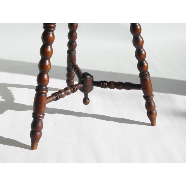 An antique carved side table with turned bobbin legs made out of Oak. The plant stand has a unique trefoil shape and...