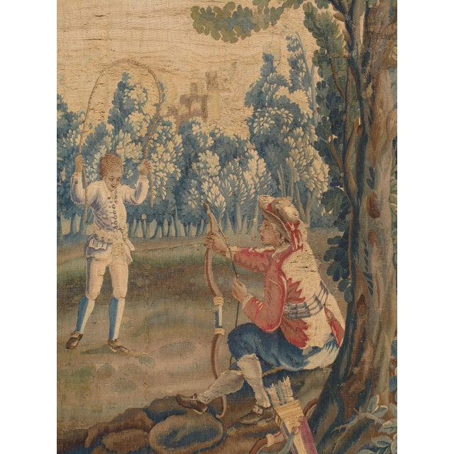 A handwoven Brussels tapestry of dancing peasants in a field with a boy playing jump rope and another with a bow and...