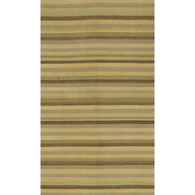 Crafted in the 1950s, this vintage Turkish Kilim is a flat-weave rug handwoven with a blend of simplicity and boldness....