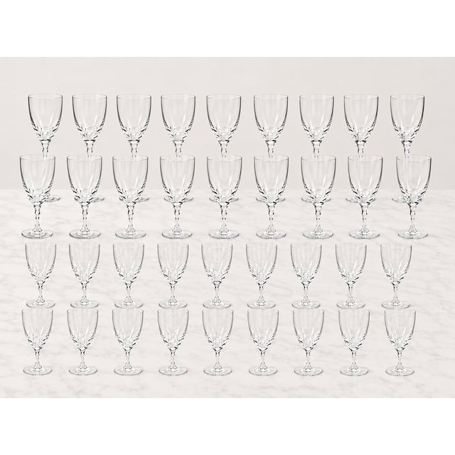 An elegant and unusually large 36-piece vintage Orrefors “Carina” crystal stemware service, designed by celebrated Swedish...