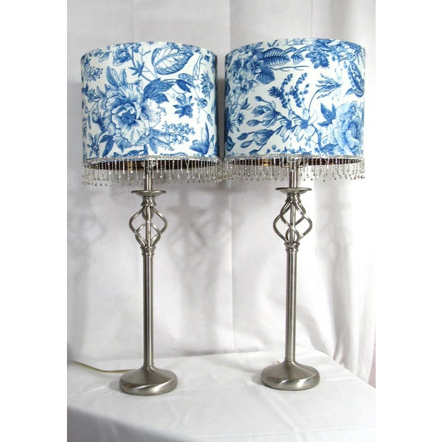 Here we have a pair of tall brushed nickel silver tone metal buffet table lamps with blue and white toile flower and bird...