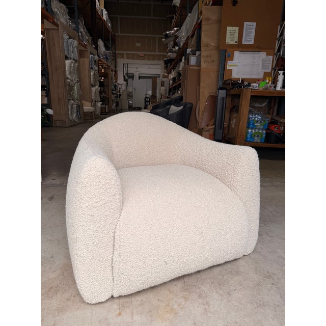 Add sculptural elegance to your home with this contemporary accent chair, upholstered in soft ivory bouclé for a warm,...
