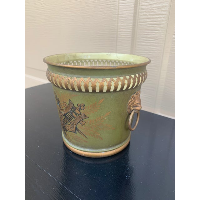A wonderfully charming early 20th century French tole cachepot finished in an olive green with delicate gilt...