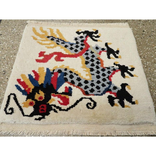 A vintage Chinese Art Deco throw rug handmade during the mid-20th century with a pictorial design of a dragon in black,...