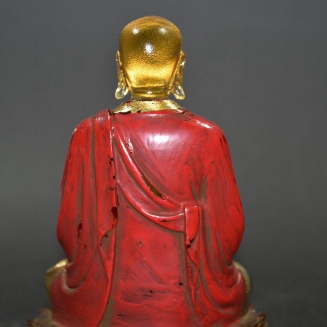 This striking figure depicts a seated enlightened being (likely a monk or arhat) in a meditative pose atop a golden lotus...