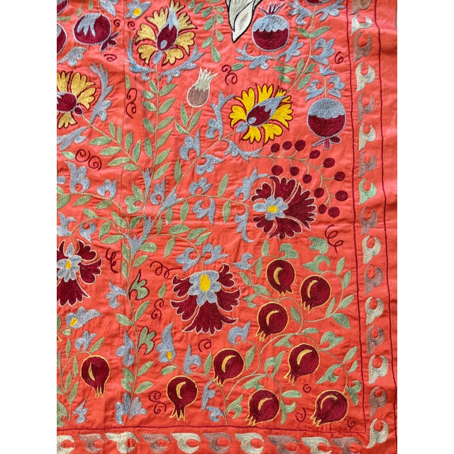 Hand-embroidered Suzani panel from Uzbekistan — two crowned white peacocks among dark red pomegranates and blue-grey...