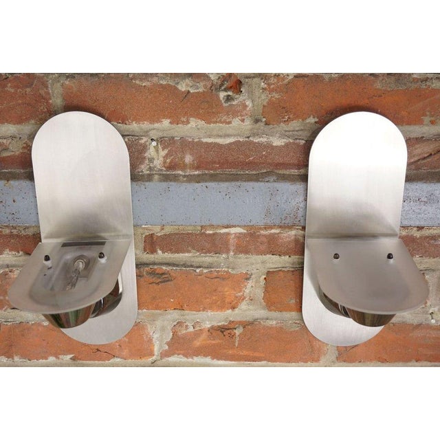 Pair of 80s design halogen wall lights in stainless steel and glass. European Plug (up to 250V).The wiring of this item...