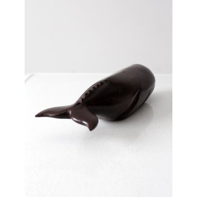 This vintage ironwood whale sculpture features a smooth, minimalist design with sleek lines and a deep, rich tone. The...