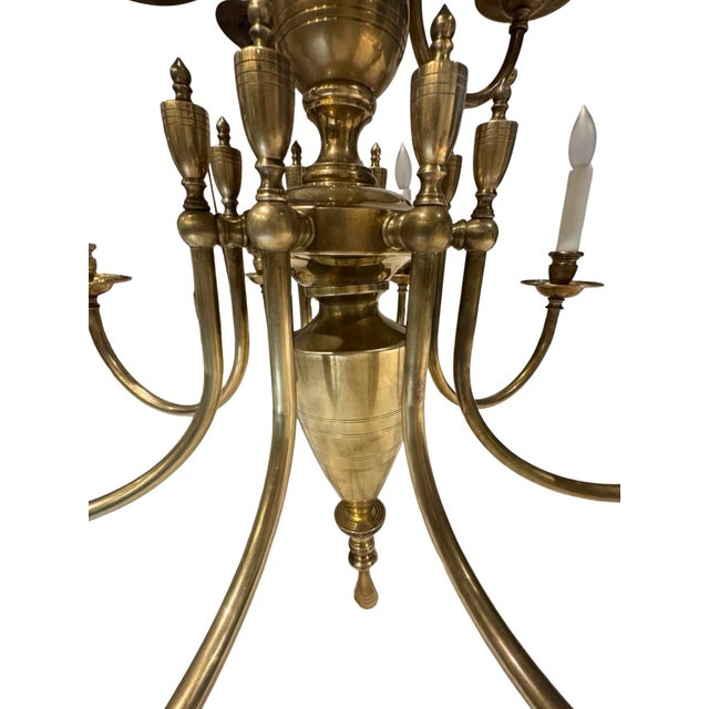 Impressive vintage twelve-light chandelier crafted in solid brass with a beautifully scaled two-tier form and gracefully...