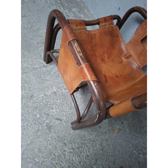 The chair is in used condition. The woodwork could use a fresh coat of oil. There are also some white paint splatters on...