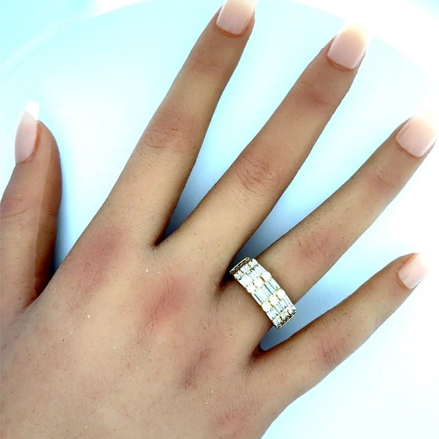 A contemporary fashion ring crafted in 18k yellow gold, featuring 2.04 carats of round brilliant and baguette-cut white...