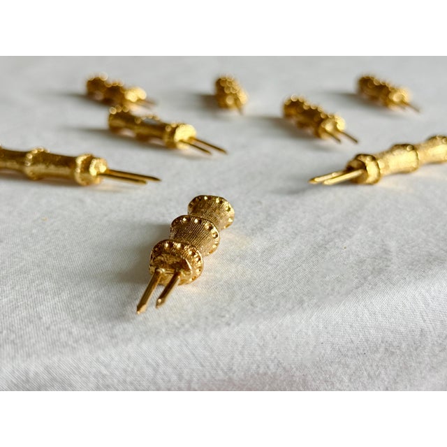 Vintage Hollywood Regency set of eight gilt bamboo corn on the cob holders, presented in the original vibrant olive green...