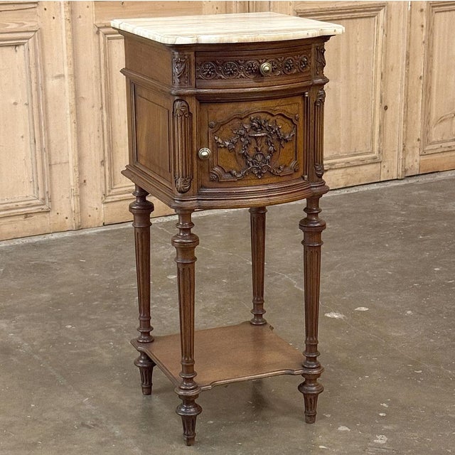 19th Century French Louis XVI Walnut Nightstand was hand-crafted from select French walnut, and features timeless...