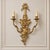 Make a dramatic statement with this ornate French-style two-light wall sconce, featuring an elaborate sculptural design...
