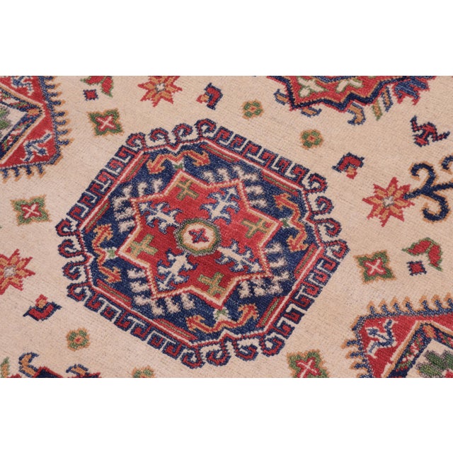 Enhance your home with this exquisite hand-knotted Kazak rug, crafted from fine hand-spun wool and dyed with all-natural...