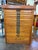 Antique oak printer’s cabinet featuring multiple shallow letterpress type drawers with decorative cast-metal label pulls...