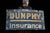 Antique painted metal storefront sign advertising Dunphy Insurance. The face features oversized yellow and white sans...