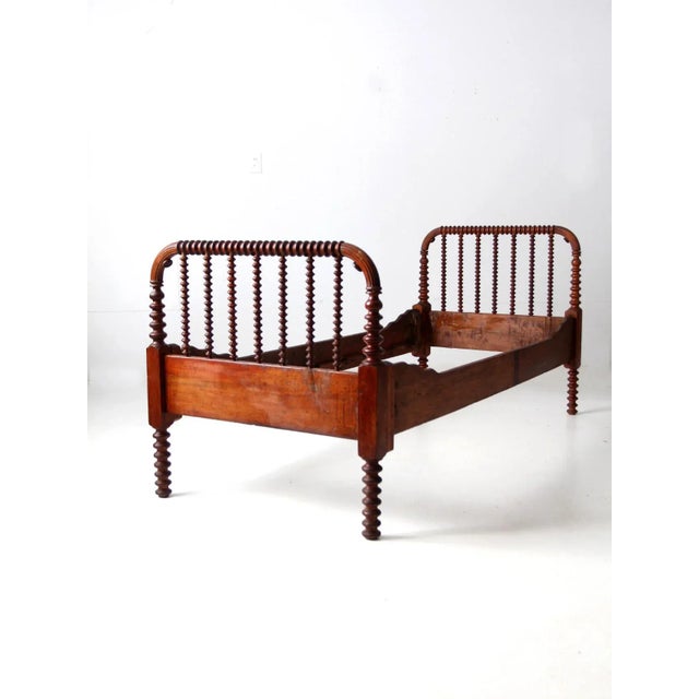 This antique Jenny Lind style wood bed frame features classic turned spindle detailing and a beautifully aged wood finish....