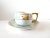 An antique teacup and saucer set, 1920s Art Deco, pale blue with black lines and golf gilt edges and handle, with bands of...