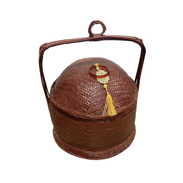 Vintage chinoiserie woven wicker storage basket and a fitted lid.. This 17" tall piece showcases jade-green carving yellow...