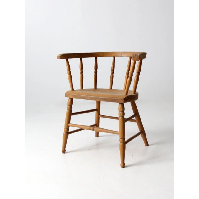 This is an antique wooden captains chair. The classic barrel seat chair feature beautifully aged wheat-tone paint and...