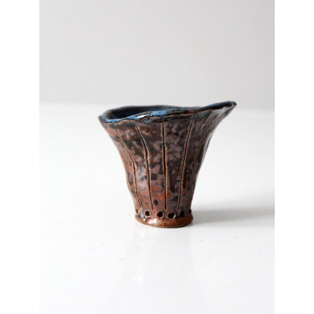 A vintage handmade studio pottery vase signed by the artist. The flared form is finished in a mottled brown glaze with a...