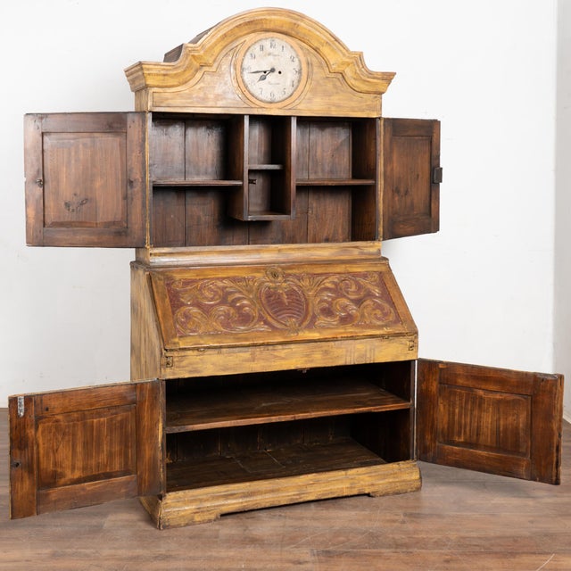 19th century Swedish pine bureau or "secretary cabinet" incorporating an upper clock feature. The piece retains an older...