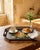 ✦ A vintage hand-painted toleware serving tray with a soft, muted floral bouquet on black and a pierced gallery rim — a...