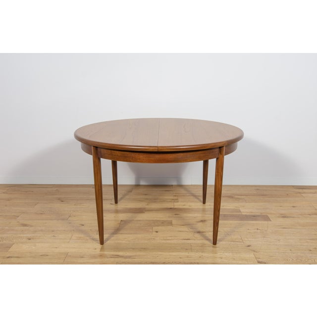 This round extendable dining table was produced by G-Plan in the 1960s. The table has profiled reinforced edges of the...