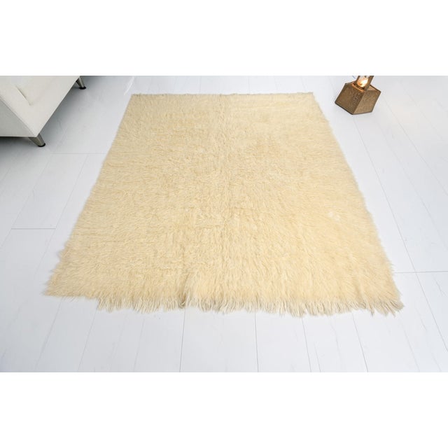 This is a vintage Turkish Oushak rug from the Mid 20th Century. The piece was hand-knotted.