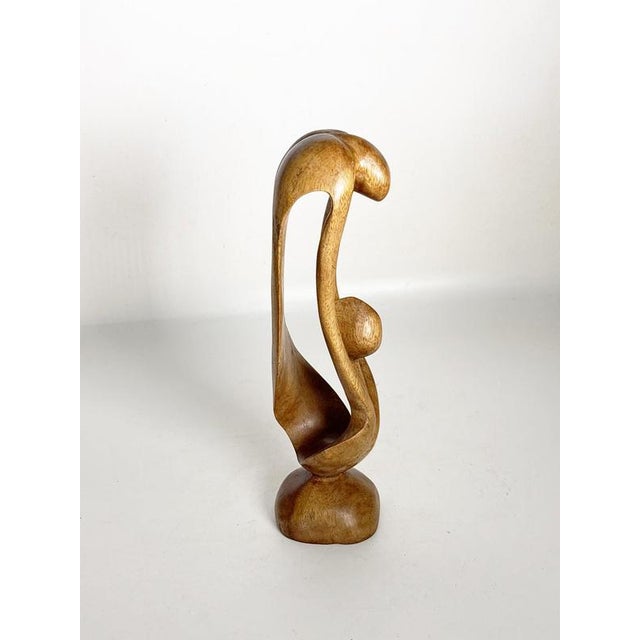 Elegant French wooden sculpture depicting a stylized mother and child, carved in an expressive modernist manner. The...