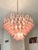 Contemporary and vintage Mazzega style chandelier. White and trasparent “Selle” elements in Murano glass poured over a...
