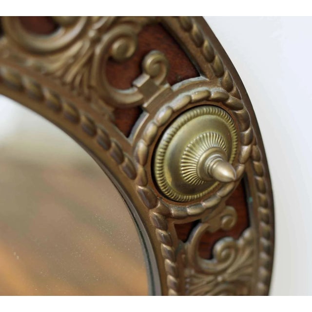 Round Brass walnut mirror with carved detail embellished with decorative red bronze and brass detail. Original...