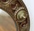 Round Brass walnut mirror with carved detail embellished with decorative red bronze and brass detail. Original...