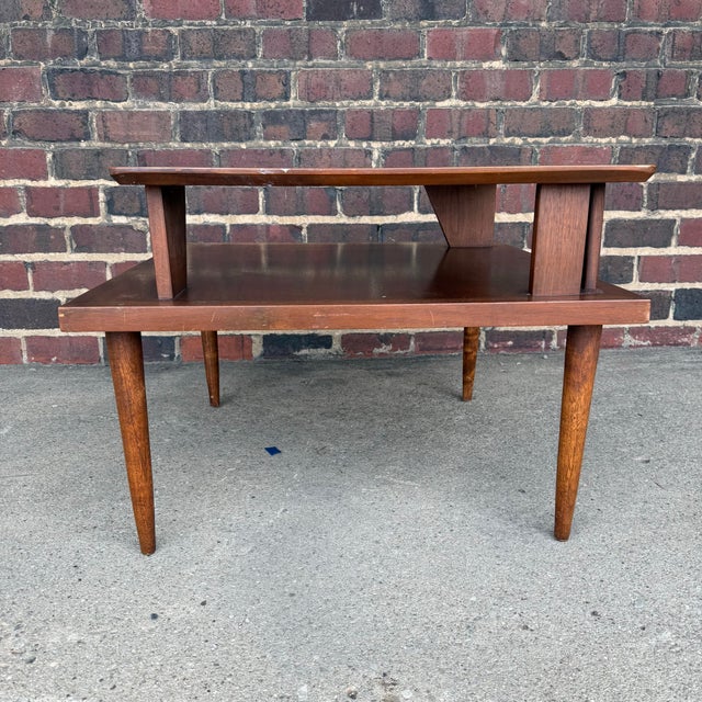 A classic mid century modern side table, perfect for situating at the corner of seating arrangements. Two-tiered...